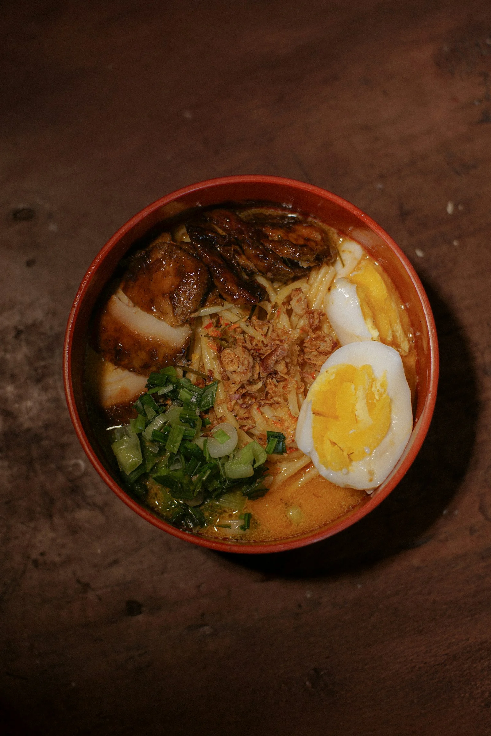 A bowl of noodle soup with chicken and egg